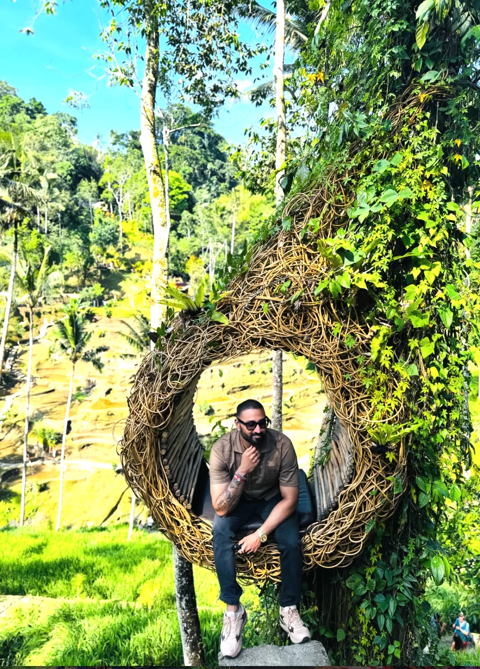 Rahul Warrier seated in an elevated woven nest overlooking the terraced rice fields in Ubud, Bali